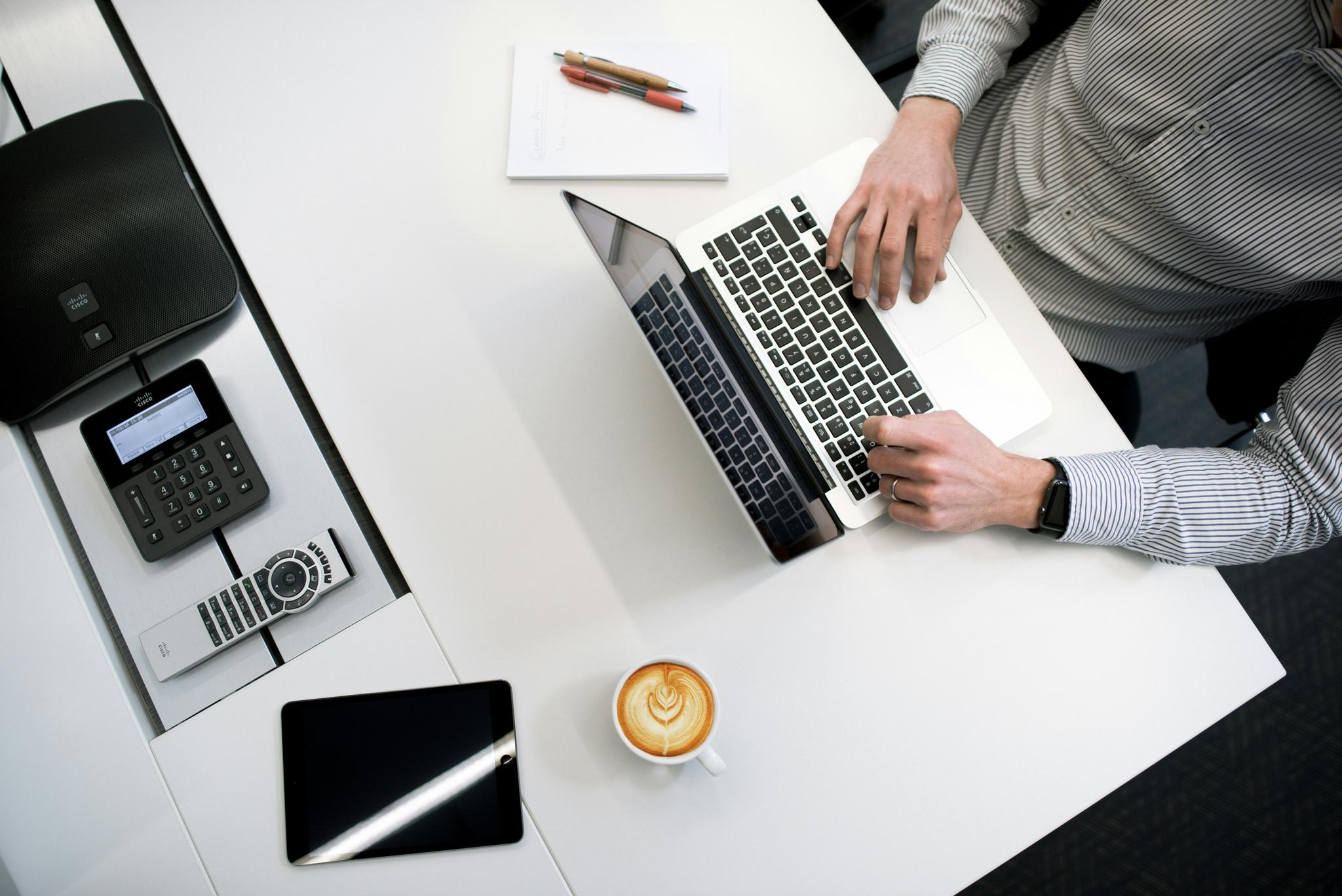 Arbeitsplatz von oben mit Laptop und Kaffee